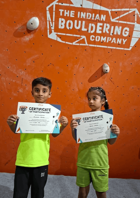 Young wall-climbing participants with certificates